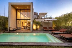 a swimming pool in front of a house at Usawa Villa Nyanyi in Munggu