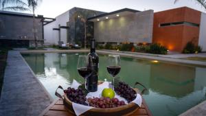 a tray of fruit and wine glasses next to a pool at Casa Diamante Viñedos in Ezequiel Montes