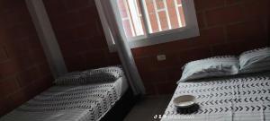 a bedroom with two twin beds and a window at Cabaña los villa in Necoclí +3 photos