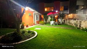 a backyard at night with a green lawn at Posada del Jardín in Huasca de Ocampo