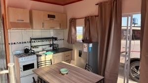 a small kitchen with a table and a refrigerator at Cuchac Cuchic in Las Compuertas