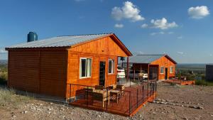 two small wooden houses sitting on top of a field at Cuchac Cuchic in Las Compuertas