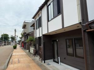 an empty street with a white and black building at なごらーれ放生津屋 in Shimminato