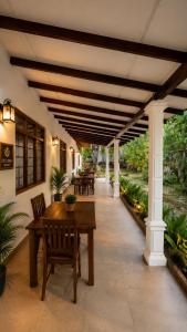 a patio with a wooden table and chairs on it at Ceylora Resort in Sigiriya