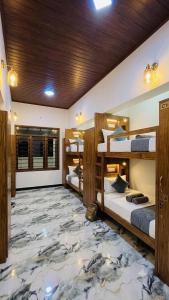 a room with three bunk beds and a marble floor at Ceylora Resort in Sigiriya