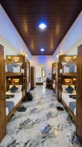 a room with four bunk beds with a marble floor at Ceylora Resort in Sigiriya +4 photos