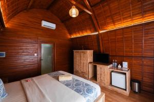 a bedroom with a bed in a wooden room at Druwa Bali in Uluwatu
