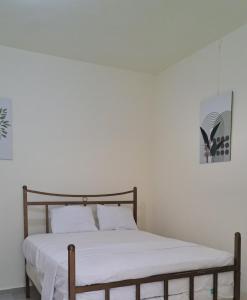a bedroom with a bed with a white bedspread at Katty House in Santa Bárbara de Samaná +4 photos