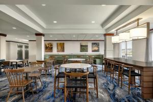 a dining room with tables and chairs and windows at Fairfield Inn & Suites by Marriott Springdale in Springdale