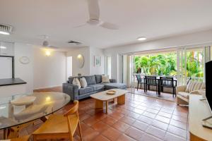 a living room with a couch and a table at Balboa Apartments in Port Douglas