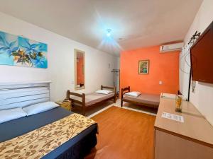 a small room with a bed and a desk and a kitchen at Pousada Anhanguera in Ribeirão Preto