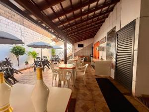 a room with a table and chairs and some bottles at Pousada Anhanguera in Ribeirão Preto