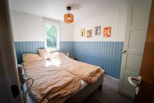 a bedroom with a bed in a room with a window at Holiday house close to nature in Glesborg