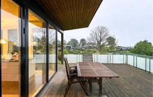 a wooden table on the deck of a house at Amazing Home In Augustenborg With Sauna in Augustenborg