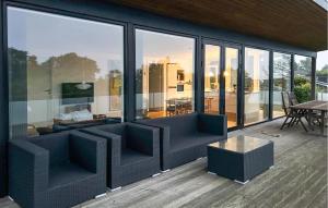 a living room with large glass windows and a table at Amazing Home In Augustenborg With Sauna in Augustenborg +26 photos