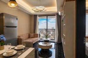 a kitchen and living room with a couch and a table at Pinnacle Moments Residence in Phnom Penh