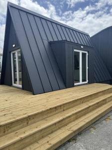 a house with a black roof and a wooden deck at Han's Solo 75 in Athenry