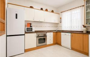 a kitchen with white cabinets and a refrigerator at Awesome Home In Abarán in Abarán