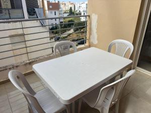 a white table and chairs on a balcony at Appartement entier 1min de la plage sable d'or in Tangier