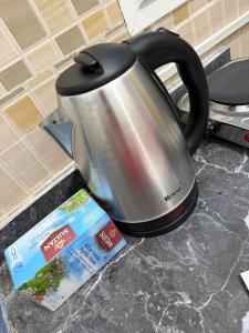 a tea kettle sitting next to a box on a counter at Appartement entier 1min de la plage sable d'or in Tangier