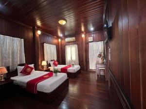 a room with two beds in a boat at Villa Vieng Sa Vanh Hotel & Travel in Luang Prabang