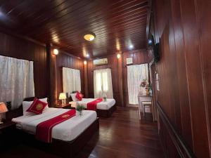 a room with two beds in a boat at Villa Vieng Sa Vanh Hotel & Travel in Luang Prabang