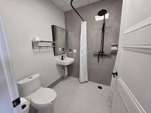 a white bathroom with a toilet and a sink at PeachView Studio 103 in Peachland +21 photos