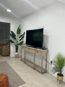 a television on a wooden table in a living room at cozy bohemian in North Miami