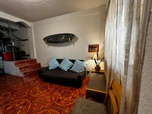 a living room with a couch and a surfboard on the wall at Beachside House with 2 bedrooms in Dalumpinas Oeste