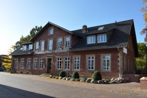 a red brick building with a black roof at Hotel Cramer Bed & Breakfast in Werlte