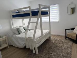 a white bunk bed in a room with a bed at Casa Brumar Beach and Downtown on Foot in Praia da Vitória