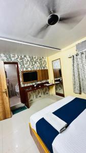 a bedroom with a bed and a tv on the wall at Hotel Raj Palace in Āzamgarh