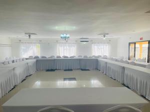 a conference room with white chairs and tables at Mana Nest Lodge in Choma