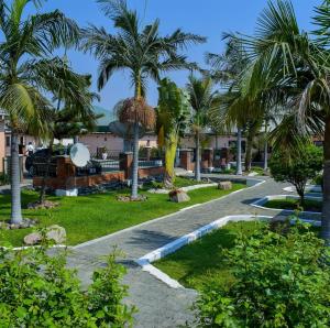 a path with palm trees in a resort at Mana Nest Lodge in Choma