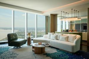 a living room with a white couch and a chair at Steigenberger Phnom Penh in Phnom Penh