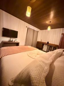 a bedroom with a bed with a tv on the wall at Villa Fênix Suítes in Barreirinhas +9 photos