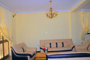 a living room with two couches and a chandelier at Abusera Bishoftu Guest House in Yerer