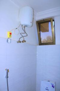 a white bathroom with a mirror and a toilet at Abusera Bishoftu Guest House in Yerer