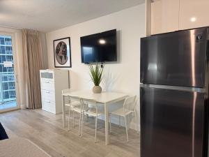a kitchen with a table and a stainless steel refrigerator at Ocean front Condo with balcony on the beach in Sunny Isles Beach