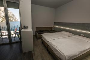 een slaapkamer met een bed en uitzicht op de oceaan bij Campione Univela Hostel in Campione del Garda