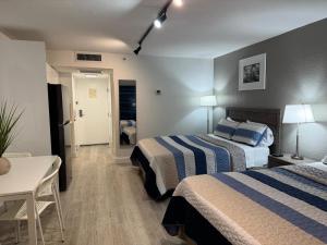 a hotel room with two beds and a table at Ocean front Condo with balcony on the beach in Sunny Isles Beach +14 photos