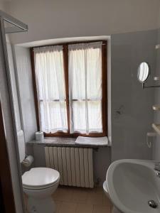 a bathroom with a toilet and a sink and a window at Nonaj in Rima San Giuseppe +9 photos