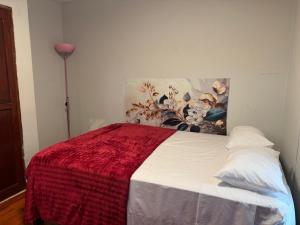 a bedroom with a bed with a red blanket on it at Hospedaje el Trujillanito in Víctor Larco Herrera