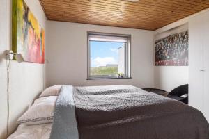 a bedroom with a large bed with a window at G213-Lemvig-Skovstjernevej-13 in Lemvig