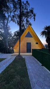 a yellow house with a tree in front of it at Magnolia Cottage in Ts'ikhisdziri
