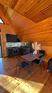 a dining room with a table and chairs and a bed at Magnolia Cottage in Ts'ikhisdziri