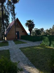 a church with a stone path in front of a building at Magnolia Cottage in Ts'ikhisdziri +8 photos