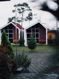 a couple of buildings with trees and a street light at CYB Merbabu Resort & Cafe in Kembang