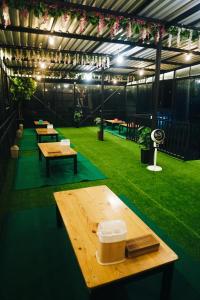 a greenhouse with benches and tables in the grass at CYB Merbabu Resort & Cafe in Kembang