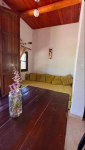 a living room with a couch and a vase with flowers at Cabaña Camping Cabalango in Cavalango
